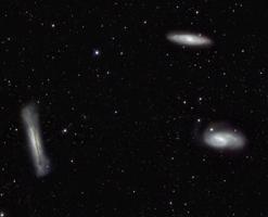 Gravitācijas spēku saistītā Lauvas galaktiku trijotne. Augšā atrodas M65, pa labi M66, bet pa kreisi – NGC 3628.
