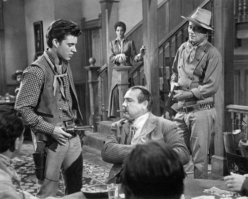 No kreisās: aktieri Rikijs Nelsons (Ricky Nelson), Endžija Dikinsone (Angie Dickinson), Nezdons Būts (Nesdon Booth) un Džons Veins (John Wayne) filmā "Rio Bravo". 1959. gads.