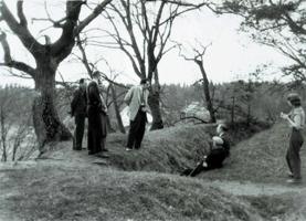 Arheologu atskaites sesijas dalībnieki izbrauciena laikā pa Daugavas senlejas arheoloģiskajiem pieminekļiem aplūko arheoloģiskās izpētes laikā atsegtās tranšejas Mūkukalna pilskalnā. 1959. gads.