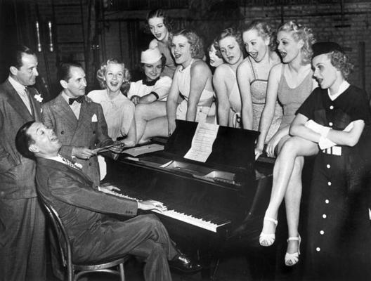 Kouls Porters (sēž pie klavierēm) mūzikla "Pagaidīsim mazulīti" (Wait for Baby) mēģinājumā ar producentu Vintonu Frīdliju (Vinton Freedley, no kreisās), horeogrāfu Džordžu Heilu (George Hale) un potenciālajām mūzikla dalībniecēm. Ņujorka, 07.07.1936.