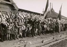 Latvijas skolēni Cēsu dzelzceļa stacijā ar ziediem un karodziņiem gaida Igaunijas valsts vecāko Jiri Jāksonu (Jüri Jaakson) vizītē Rīgā. 05.1925.