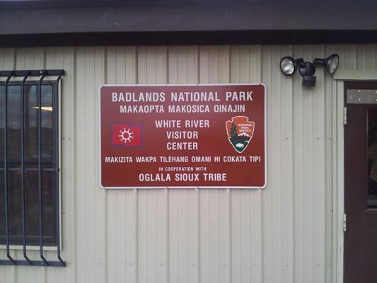 Uzraksts siū un angļu valodā pie Bedlendsas nacionālā parka Vaitriveras apmeklētāju centra Painridžas rezervātā, Dienviddakotas pavalstī, 2012. gads.