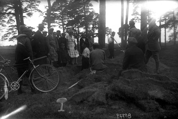 Skolēni ekskursijas laikā iepazīstas ar arheoloģisko izrakumu procesu Priediena senkapos. Grobiņas pagasts, 1929. gads.