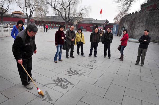 Ielu mākslinieks raksta ķīnzīmes parkā uz bruģa. Pekina, Ķīna, 11.03.2009.