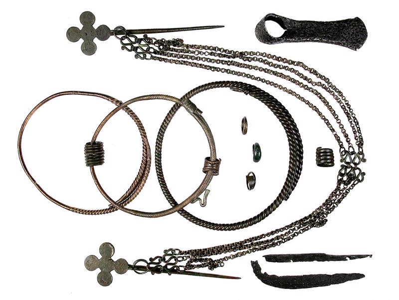 Senlietas no sievietes apbedījuma: bronzas kaklariņķi, gredzeni, važiņrota ar divām krustdatām, dzelzs sirpis, nazis, kaplis. Jaunsvirlaukas Ciemalde, 11. gs.