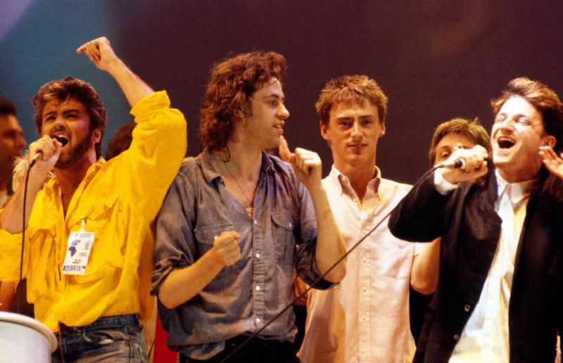 No kreisās: Džordžs Maikls, Bobs Geldofs, Pols Vellers (Paul Weller) un Bono dzied dziesmu "Do They Know It’s Christmas?" Live Aid koncerta noslēgumā. Vemblija stadions, Londona, 13.07.1985.