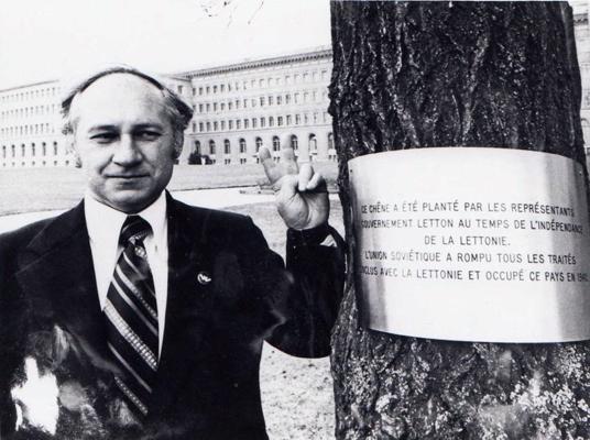 Ilgvars Spilners pie 1923. gadā Latvijas Republikas valdības delegācijas stādītā ozola un no jauna piestiprinātās plāksnes par ozola stādītājiem un Latvijas okupācijas faktu. Ženēva, 1974. gads.