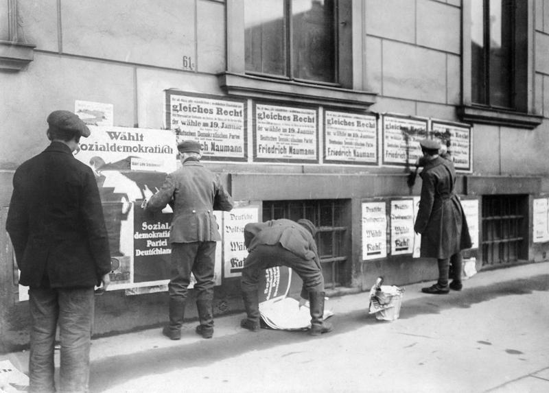 Vācijas Sociāldemokrātiskās partijas atbalstītāji aizlīmē opozicionāro politisko spēku plakātus. 10.01.1919.