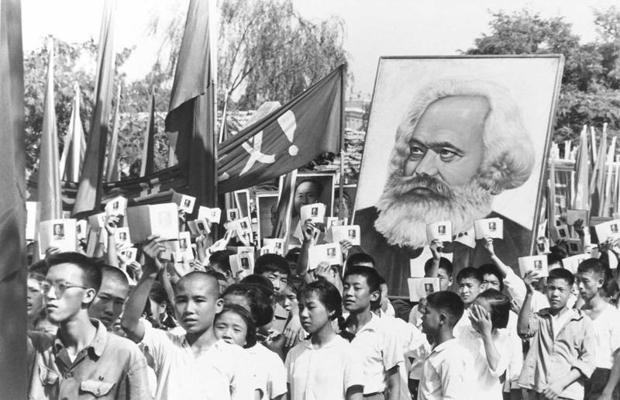 Jaunieši mītiņā nes Kārļa Marksa plakātu un rokās tur Mao Dzeduna rakstu kopijas, dēvētas par Mao Mazo sarkano grāmatu. Ķīna, 14.09.1966.