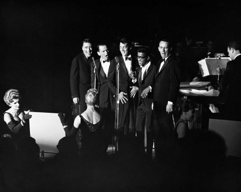 Grupas Rat Pack uzstāšanās. No kreisās: Pīters Lofords (Peter Lawford), Frenks Sinatra, Dīns Mārtins, Samijs Deiviss jaunākais un Džoijs Bišops (Joey Bishop). 20. gs. 60. gadi.