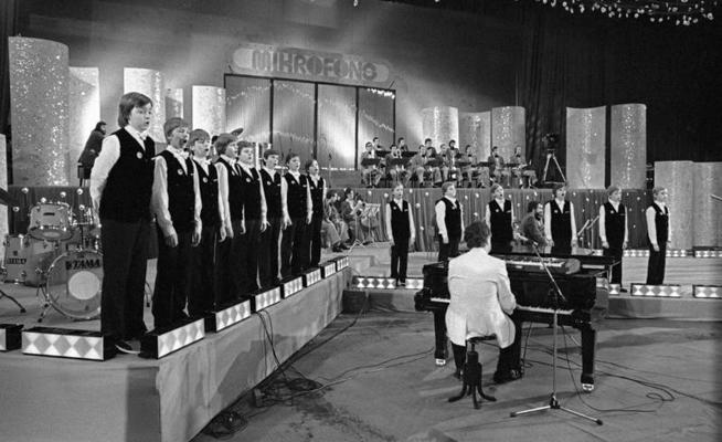 Emīla Dārziņa vidusskolas zēnu koris, pie klavierēm Raimonds Pauls dziesmu konkursā "Mikrofona" aptauja. Rīga, 12.1982.