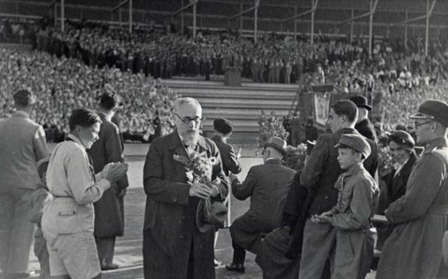 Alfrēds Kalniņš (ar ziediem rokās) starp IX Vispārējo latviešu dziesmu svētku skatītājiem. Rīga, 06.1938.