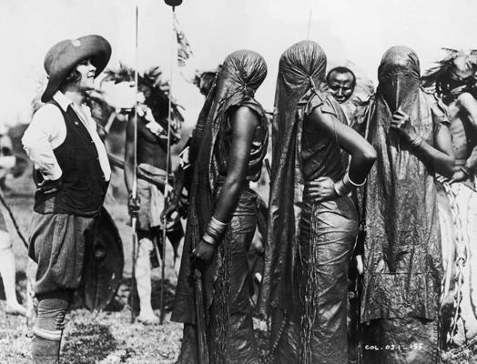 Amerikāņu antropoloģe Osa Džonsone (Osa Johnson) ar lumbvu (kipsigi) jaunām sievietēm ar aizsegtām sejām. Kenija, 1925. gads.