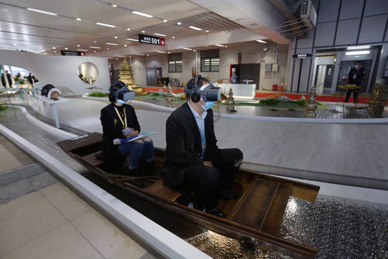 Apmeklētāji ar virtuālās realitātes hologrāfisko briļļu palīdzību piedzīvo izbraucienu ar laivu pa Rietumu ezeru 3. Ķīnas Starptautiskās importa izstādes laikā (China International Import Expo). Nacionālais izstāžu un sanāksmju centrs, Šanhaja, Ķīna, 05.11.2020.